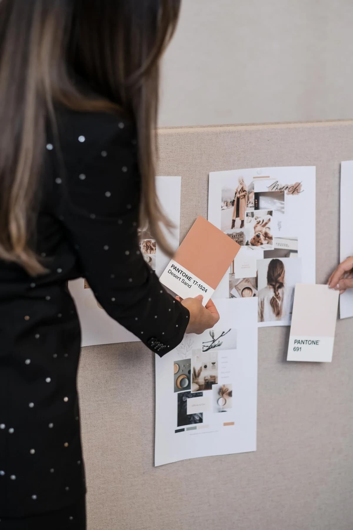 Noemi comparing warm colour swatches at a moodboard